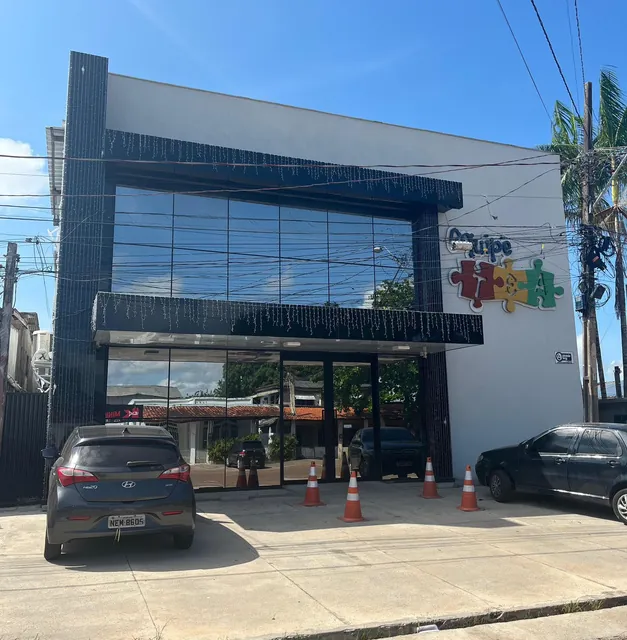 Fachada da Equipe TEA, com vidro espelhado e o logo de peças de quebra-cabeça na parede branca, na Av. dos Timbiras, em Macapá